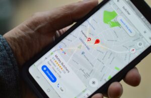 Téléphone dans une main qui suivit un GPS sur Google Maps