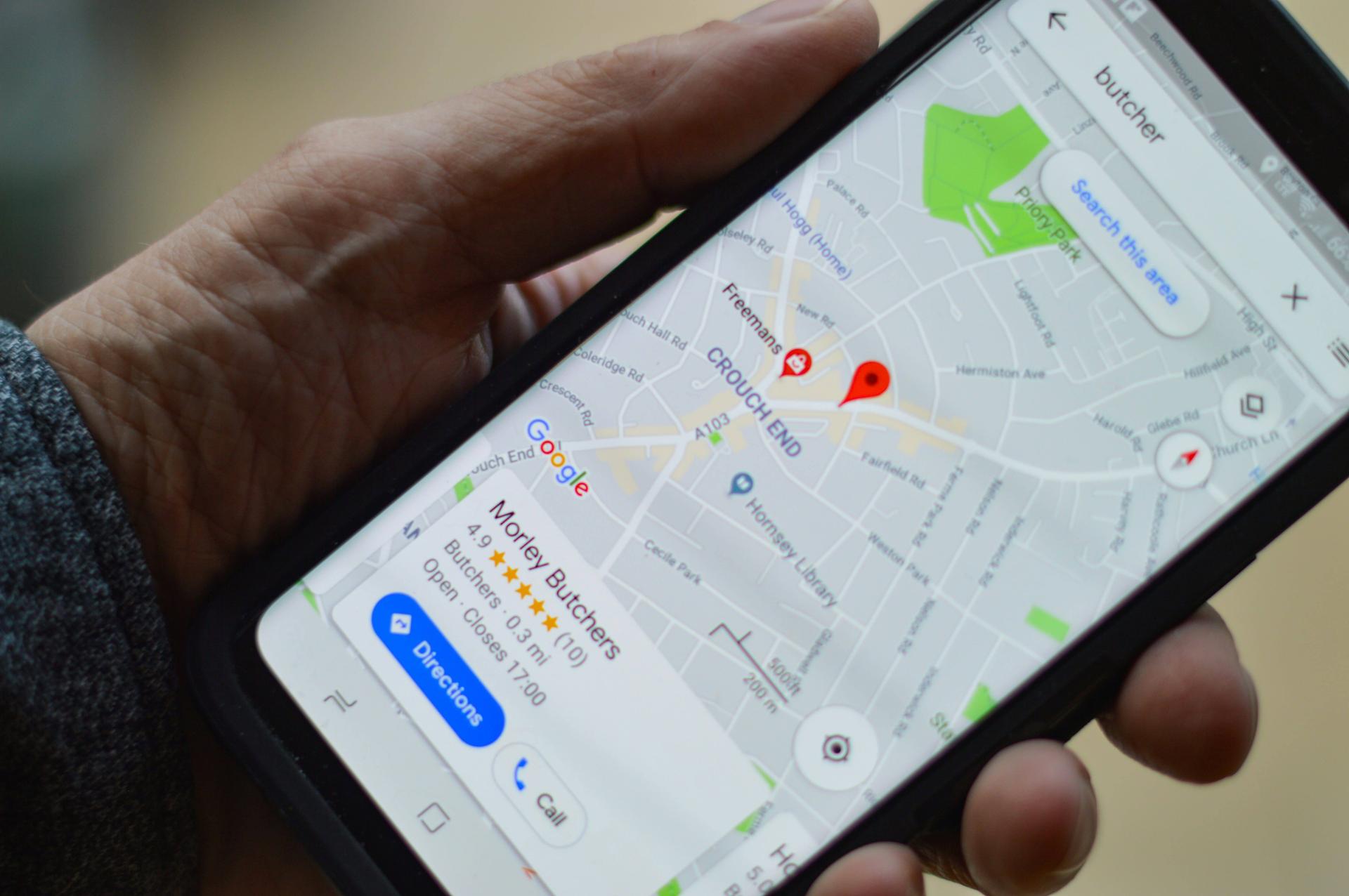 Téléphone dans une main qui suivit un GPS sur Google Maps